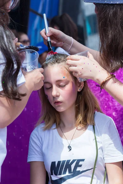 Almaty, Kazachstan - 10 juni, 2018: Onbekende meisje make-up artiest maakt een heldere carnaval gezicht schilderen aan het festival deelnemers op het feest van de Yarkokros in de buurt van het stadion van Almaty Arena op 10 juni — Stockfoto