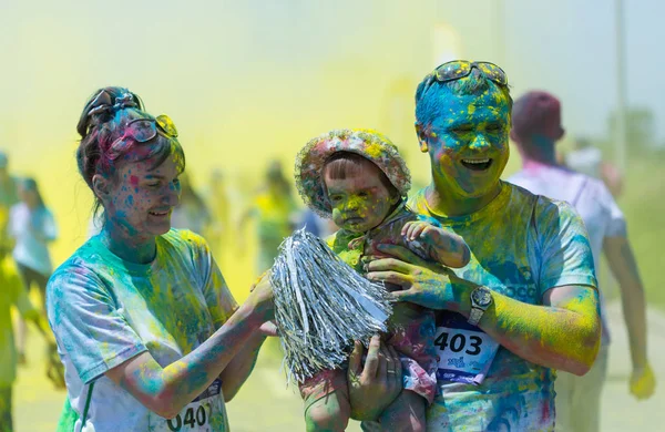 ALMATY, KAZAKHSTAN - JUNE 10, 2018: Unknown family together sprinkled with bright paint are smiling at the Yarkokros party near the Almaty Arena stadium on June 10, Sunday in the city of Almaty. — Stock Photo, Image