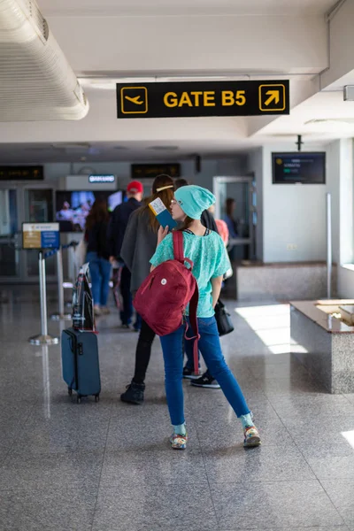 Asiatisk tonårs flicka använder en smartphone för att kontrol lera flygningen på den internationella flyg platsen för att resa på helgerna. — Stockfoto