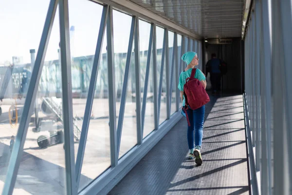 Ung kvinna i ombordstigning bron på flygplatsen — Stockfoto