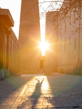 denim hipster giysileri komik yaratıcı genç kız büyük gölge yapma güneş ışınlarına karşı atlama.
