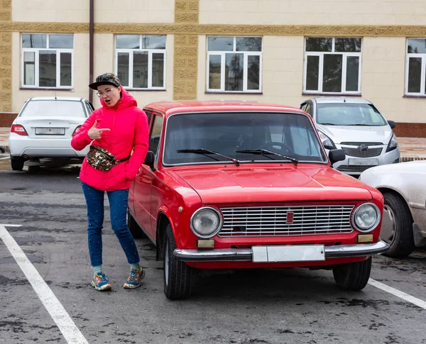 Kırmızı retro Lada arabasına yaslanan kadın — Stok fotoğraf