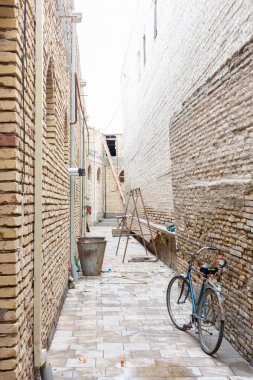 Eski tuğla duvar ve kopya alanı ile siyah retro vintage bisiklet. Retro bisiklet eski tuğla duvarın önünde sepeti ile. Retro vintage tuğla duvar arka plan ile yol kenarında bisikletle.