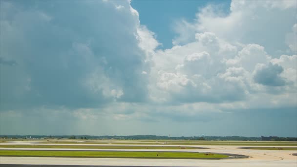 アトランタ国際空港で不吉な雲に離陸する民間旅客機と飛行場の広い側面の眺め — ストック動画