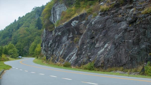 西ノースカロライナ州のスモーキー山脈のアッシュビルに近い夏に石垣を過ぎてブルーリッジパークウェイを運転するファミリーセダン — ストック動画