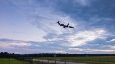 İşaretsiz Bölgesel Jet Uçağı Son Yaklaşma İniş ve Erken Akşam veya Sabah Geniş Açıdan Gökyüzünde Canlı Renkler ile Gelen