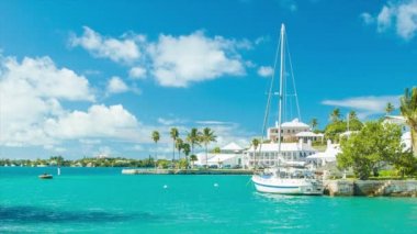 St Georges Harbor Bermuda Güneşli Bir Günde Arka Planda Turkuaz Renkli Su Yeşil Palmiye Ağaçları Bermudan Mimarisi bir Yat ve Mavi Gökyüzünde Beyaz Bulutlar featuring bir Feribot Crossing ile