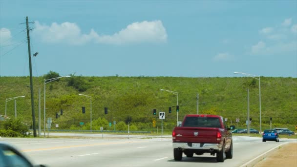 青空を背景に通過デルタ航空ジェット機でアトランタ空港の隣の道路を走行する車 — ストック動画