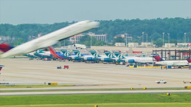 达美航空公司喷气式飞机起飞与各种客机排队在哈特斯菲尔德杰克逊亚特兰大国际机场的终端背景 — 图库视频影像