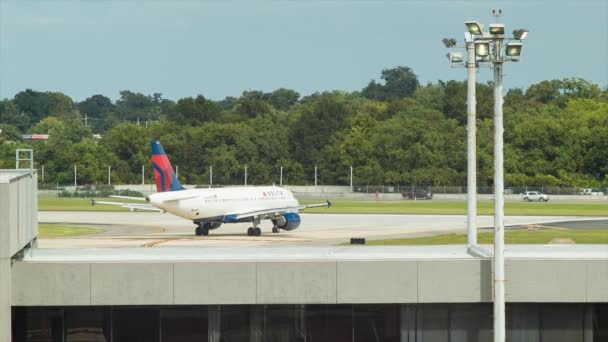 デルタ航空エアバスA319 114民間ジェット旅客機がルイ アームストロング ニューオーリンズ国際空港から離陸する準備が整った滑走路に向かう — ストック動画