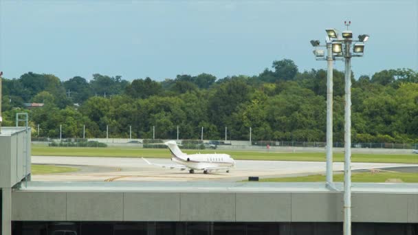 アームストロング ニューオーリンズ国際空港の滑走路に向かってタキシングするプライベート無印エグゼクティブビジネスジェット機 — ストック動画