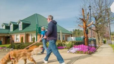 Çift Güzel güneşli bir bahar sabahı Tarihi Downtown Hendersonville, Nc Ziyaretçi Merkezi geçmiş Main Street onların Köpekler Yürüyüş.