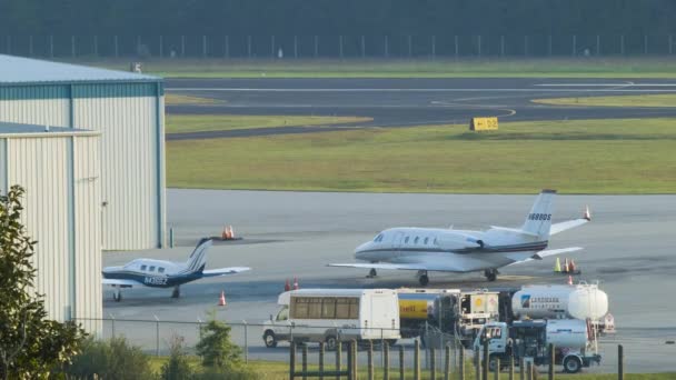 西ノースカロライナ州のブルーリッジ山脈の夏の間にアッシュビル地域空港でジェット機とサポート車両との民間航空アクション — ストック動画