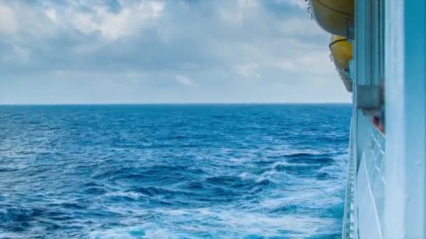 在航行开放海洋的游轮上 救生船悬挂在船的侧面 带有海景地平线和云彩 — 图库视频影像