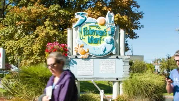フィッシャーマンズワーフビクトリアブリティッシュコロンビアカナダ入口看板は 晴れた日に人気の観光スポットに歩いて人々と — ストック動画