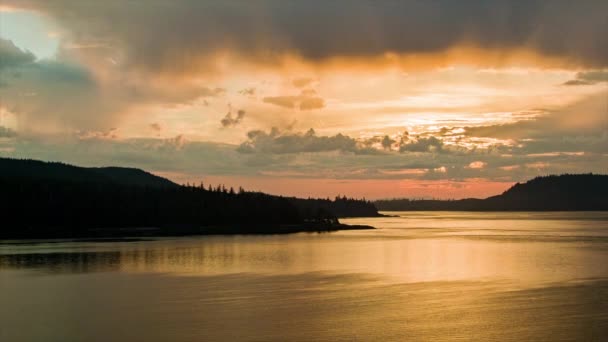 金色的阿拉斯加日落日出景观在海上具有史诗般的云充满天空和橙色太阳反射在海水 — 图库视频影像