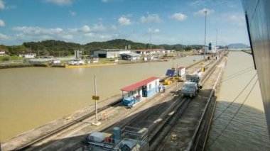 Orta Amerika'da Güneşli ve Sıcak Bir Günde Lokomotif Trenler tarafından Panama Kanalı'nda Kilitlere Yönlendirilen Gemi