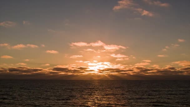 바다에서 바다의 배에서 움직이는 수평선과 태양에서 하늘로 방출되는 오렌지 광선과 — 비디오