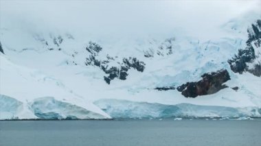 Mavi ve Beyaz Renkli Buz Kaplı Kaya Oluşumları ile Dondurulmuş Antarktika Dağ Manzara Genelinde Panning