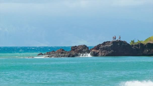 カアナパリビーチマウイハワイのブラックロックの上に立つ人々は 下に熱帯ブルー太平洋の水を持つ — ストック動画