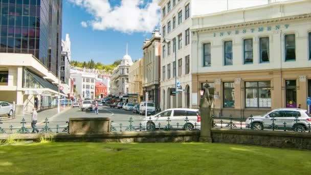 車を運転し ダウンタウンの建物の中を歩く人々とモレイプレイスでダニーデンニュージーランド市内中心部のストリートシーン — ストック動画
