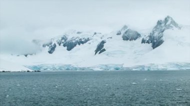 Uzun Buz Kaplı Dağlar ve Hareketli Güney Okyanus Suyu ile Dondurucu Soğuk Antarktika