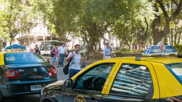 出租车在布宜诺斯艾利斯阿根廷街头场景与路过的人和公共巴士交通在公园旁边的佛罗里达街在城市受欢迎的中央购物区 — 图库视频影像