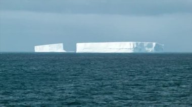 Büyük Buzdağı Bloklar Orta Shot Buz yansıyan Güneş ışığı ile Güneşli Bir Günde Antarktika etrafında Güney Okyanusu'nda Yüzen