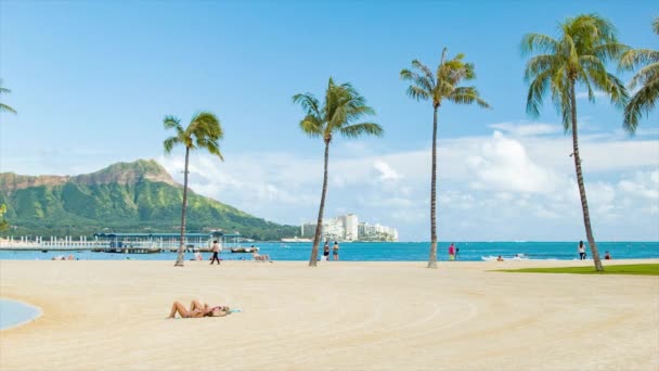 熱帯の楽園で晴れた日に日光浴をする人々とホノルルハワイのワイキキビーチ — ストック動画