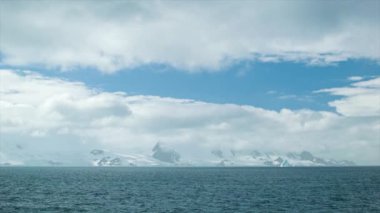 Buzdağları ve Moody Bulutlar featuring Mavi Gökyüzü Açılış ile Sunny Antarktika Manzara Geniş Shot