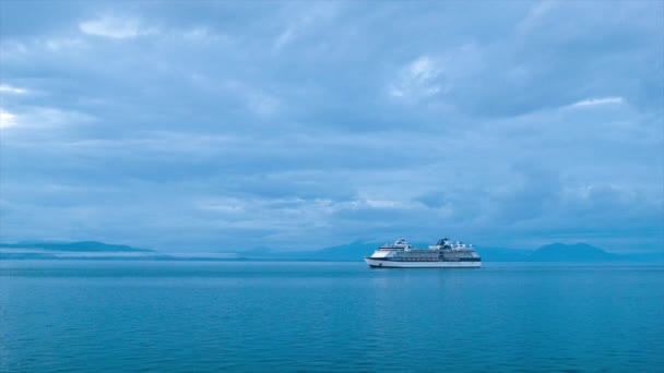 マウンテンコーストラインの背景を持つ静かなアラスカ海域でブルーイブニングクルーズ中にセレブミレニアムクルーズ船ロングショット — ストック動画