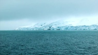 Soğuk Havalarda Buz ve Karla Kaplı Kayalarla Güney Okyanusu'ndaki Bir Gemiden Antarktika Kara Kütlesinin Görünümü