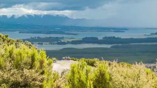 陶兰加 新西兰 两个人坐在曼加努伊山山顶的长凳上 可以欣赏到丰盛湾地区的壮丽景色 — 图库视频影像