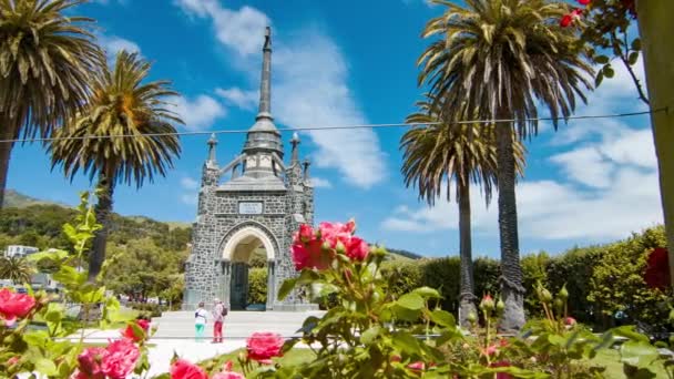 Akaroa New Zealand Touristen Besuchen Kriegsdenkmal Zwischen Bunten Rosa Blumen — Stockvideo