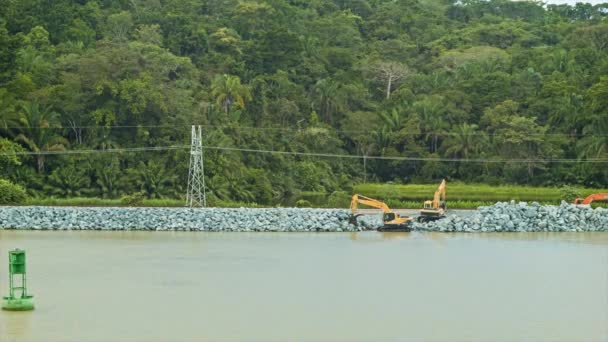 産業用土陸動機器を備えたガトゥン湖の端に緑豊かな熱帯ジャングルの背景を持つパナマ運河建設 — ストック動画