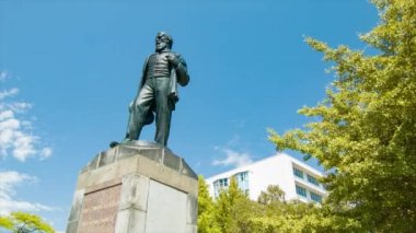 Christchurch NZ Botanik Bahçeleri Ilk baş komiser James Edward Fitzgerald heykeli Park girişinde yeşil ağaçlar ve mavi gökyüzü ile güneşli bir gün