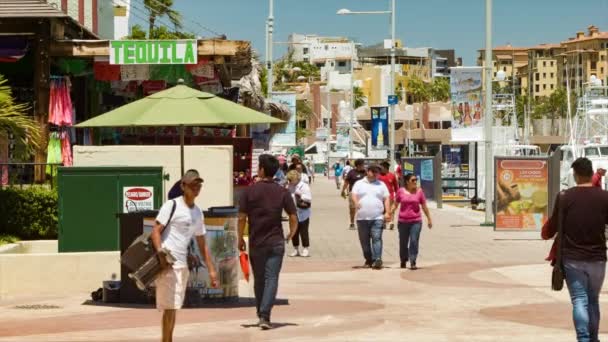 卡波圣卢卡斯游客沿着滨海港人行道码头与商店和酒吧在炎热的一天排队 — 图库视频影像
