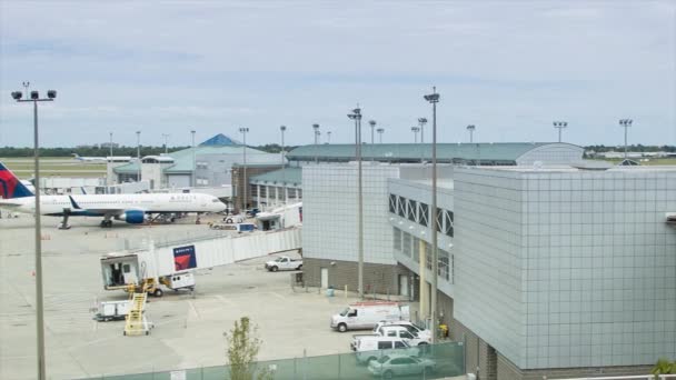 ボーイング757とエアバスA319航空機がゲートに駐車したデルタ航空ターミナルでニューオーリンズ空港ワイドパンニングショット — ストック動画