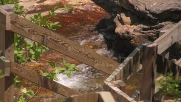 在北卡罗来纳州西部阿什维尔和韦恩斯维尔之间的蓝岭公园道下瀑布下瀑布的木楼梯后 河流在岩层上的特写 — 图库视频影像