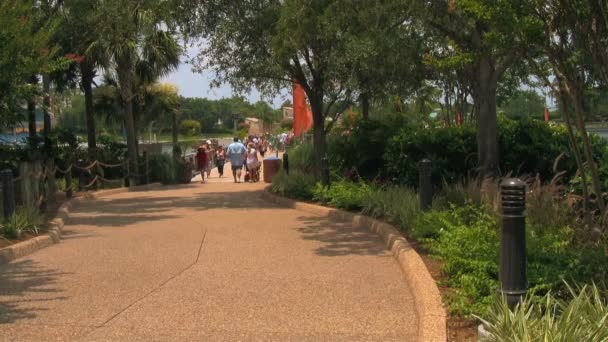 オーランドのシーワールドアドベンチャーパークへの訪問者 フロリダ州は暑い夏の日に乗り物とアトラクションの間の経路に沿って歩いています — ストック動画