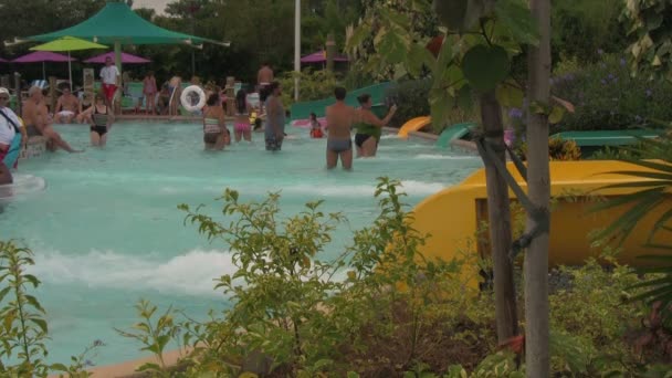 Famílias Desfrutando Escorregas Tubo Água Terminando Com Respingo Piscina Parque — Vídeo de Stock