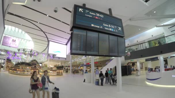 シドニーオーストラリアキングスフォードスミス国際空港インテリアターミナル免税店で乗客の買い物や過去の情報看板を歩く — ストック動画