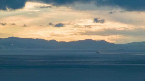 ジブラルタルの海峡の夕日のタイムラプスを通過船とオレンジ色の太陽色の移動雲と背景にモロッコの山脈 — ストック動画