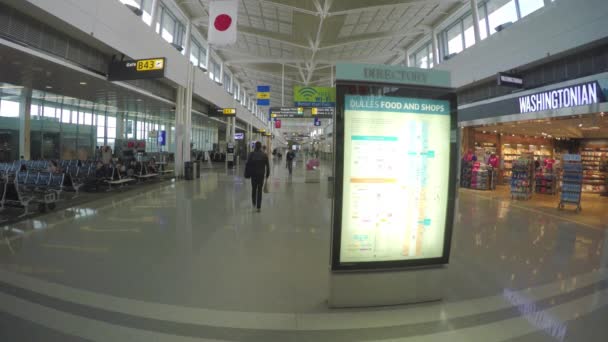 ワシントンDcダレス空港ターミナルBゲート内のお店と人々がディレクトリ看板に沿って歩き 彼らのフライトを待っています — ストック動画