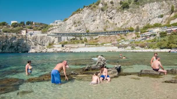 タオルミーナシチリア島のポプライタリアリゾートデスティネーションで夏休み中にイソラベラビーチで泳ぐタオルイリイタリア家族 — ストック動画