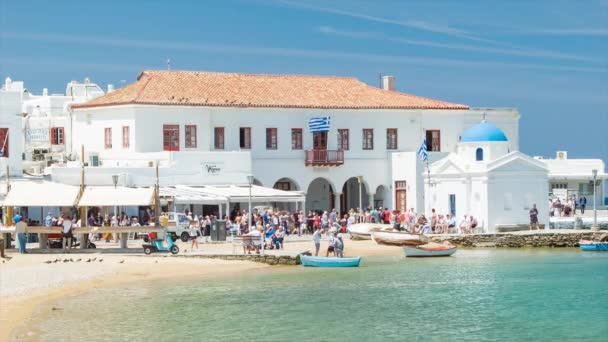 地中海の島の晴れた夏の日に地元の文化を体験する観光客とミコノスギリシャの地元のギリシャのウォーターフロント市場 — ストック動画