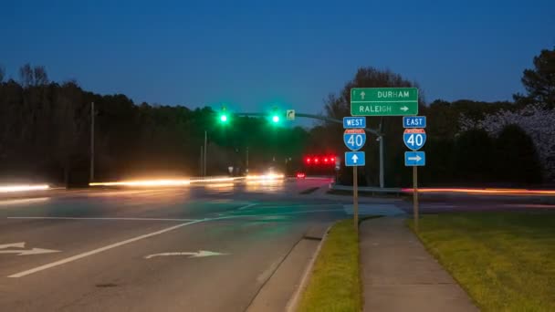 ローリーダーラムNc州間高速道路40トラフィックタイムラプスは 東西道路沿い方向標識を通過する高速移動車両との出口インターチェンジでのタイムラプス — ストック動画