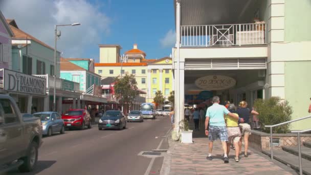 拿骚巴哈马游客在高端商店购物走在繁忙的岛屿市中心街的人行道店面 — 图库视频影像