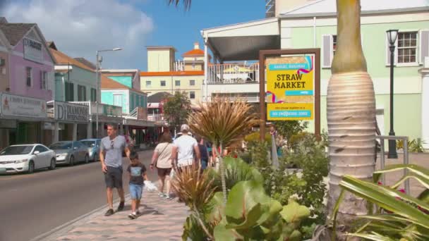 拿骚巴哈马稻草市场五颜六色的标牌外部与观光游客步行和购物在市中心在阳光明媚和充满活力的一天 — 图库视频影像