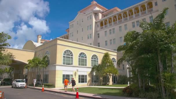 拿骚巴哈马英国殖民地希尔顿前楼外部在阳光明媚的日子与游客和车辆在巴哈马首都市中心的历史酒店地标 — 图库视频影像